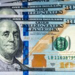 los-nuevos-billetes-de-cien-dolares-sobre-fondo-de-madera-e8txwa