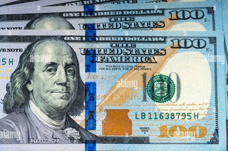 los-nuevos-billetes-de-cien-dolares-sobre-fondo-de-madera-e8txwa